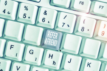 Word writing text Refer A Friend. Business photo showcasing direct someone to another or send him something like gift White pc keyboard with empty note paper above white background key copy space