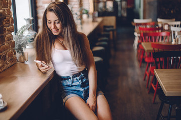Woman using phone  in a cafe.