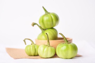 Close up of organic raw green tomato on a white background