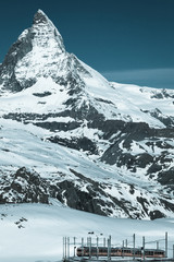 Spectacular view of the Matterhorn and Gornergrat tourist train from Gornergrat Bahn, Switzerland. Cold tone.