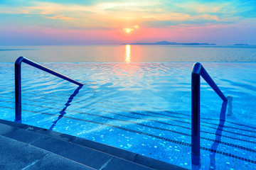 Swimming pool with stair and sunset background