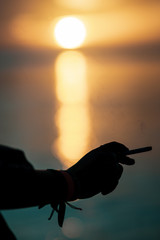 silhouette of hand wit cigarette while sunset, Jamaica, Caribbean