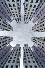 Look up of skyscrapers with cotton clouds. Target the sky