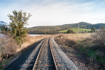 Fototapeta na wymiar Railroad railing, railway going through countryside landscape