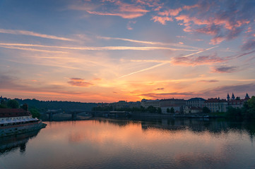 Sunrise in Prague with Vltava river and historic waterfront buildings