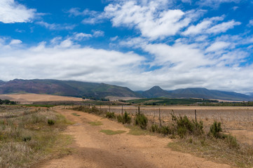 Countryside landscape with unsealed dirt road and mountains