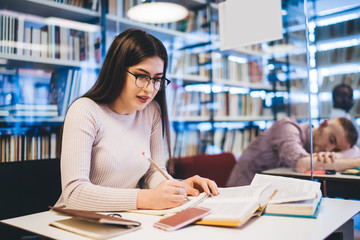 Optimistic lady reading in bright library