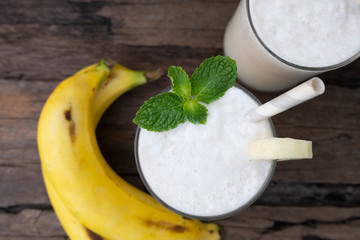 Coconut blend banana milk smoothie drink fresh cocktail shake milkshake vanilla juice fruit beverage food healthy the taste yummy In glass on wooden background from top view.