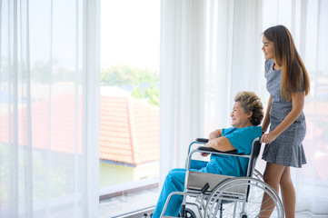 Obraz premium Asian daughter or care assistant helping support senior woman or mother
