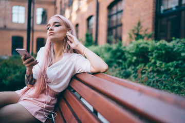 Fototapeta premium Alluring skinny woman enjoying music in street