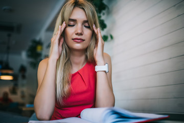 Fototapeta premium Female student touching temples and concentrating