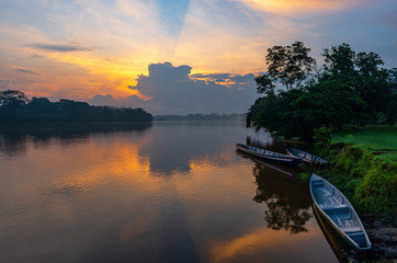 Canoes along the riverbank of the Cuyabeno Wildlife Reserve at sunset in the Amazon River Basin,...