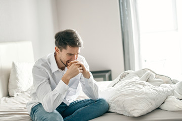 man sitting on sofa and talking on cell phone