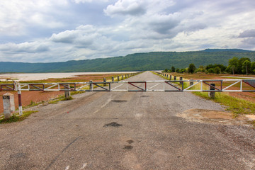 Car driving on road with Safety barrier at a dam.