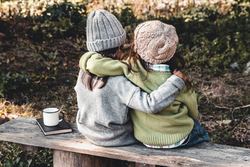 Two happy girls as friends hug each other. Little girlfriends in park. Children Friendship.