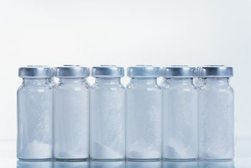 Glass medical ampoule vial for injection. Medicine is dry white drug penicillin powder or liquid...