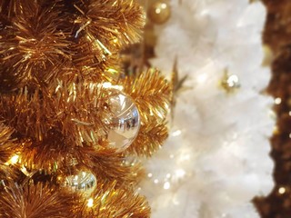 Christmas tree covered in snow decorated with beautiful ornaments and lighting,celebrate  seasonal.garland background and xmas wallpaper.golden christmas tree decoration