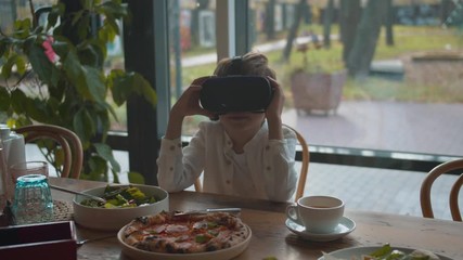 Boy looking around in virtual reality glasses at lunch - Powered by Adobe