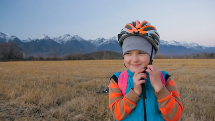 One caucasian children walk with bike in wheat field. Little girl walking black orange cycle on...