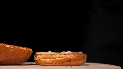 Craft burger is cooking on black background in black food gloves. Consist: sauce, lettuce, tomato, red onion, pickle, cheese, bacon, air bun and marbled meat beef. Not made ideal. Looks real, loving