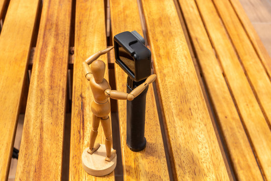 Wooden dummy with a photo and video camera on a deck