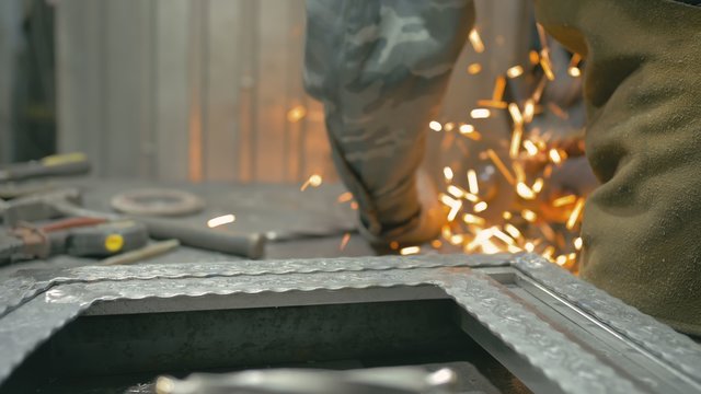 Forge workshop on table. Smithy manual production. Work on the product. Ruler, angle grinder. The blacksmith makes iron products for manufacture of fireplaces, stoves. - Powered by Adobe