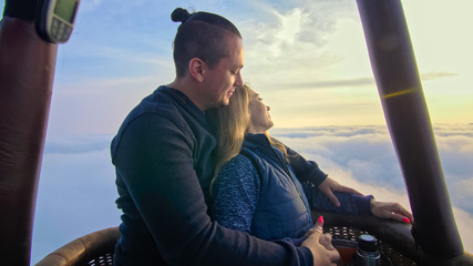 Adventure love couple on hot air balloon watermelon. Man and woman kiss hug love each other. Burner...