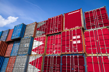 Fototapeta premium The national flag of Bahrain on a large number of metal containers for storing goods stacked in rows on top of each other. Conception of storage of goods by importers, exporters