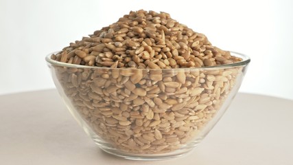 Nuts sunflower rotate are on a table in a plate. Snack in transparent dish on an isolated white...