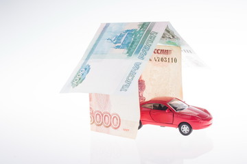 toy red car in the garage made of banknotes. real estate concept
