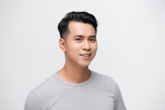 Smiling young handsome Asian man face studio shot isolated