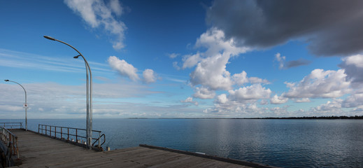 panorama of the sea strecthing along an old timber pier and out into the bay with a calm sea and...