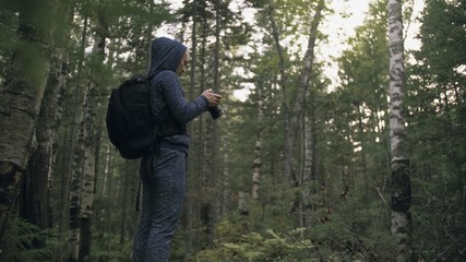 Traveler photographing scenic view in forest. One caucasian woman shooting nice magic look. Girl take photo video on dslr mirrorless camera. Professional photographer travel with backpack. Outdoor.