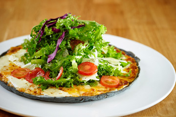 Fototapeta na wymiar Black dough salad pizza with black pepper 
