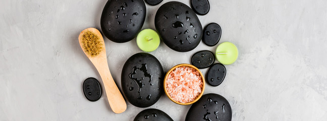 Top view of hot spa stones set for massage treatment on gray concrete background with copy space. Elegant and luxury spa. Flat lay, overhead, mock up, template. Health and beauty care concept