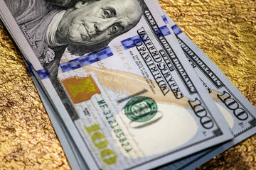 One hundred dollars stack on a gold close-up