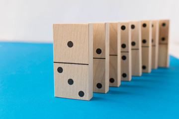 Playing dominoes on a white blue background. Leisure games concept. Domino effect.
