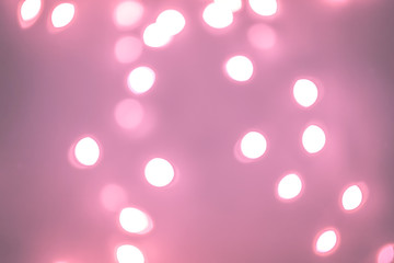Pink Festive Christmas Beautiful abstract Background with bokeh lights. Holiday Texture with copy space. Can be used as Wallpaper, filling for a website, defocused