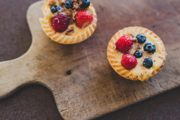 berries custard and chocolate pastries on cutting board