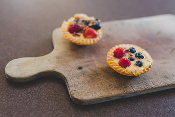 berries custard and chocolate pastries on cutting board