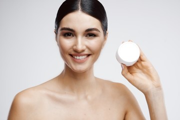 Obraz na płótnie Canvas woman applying moisturizer cream on her face
