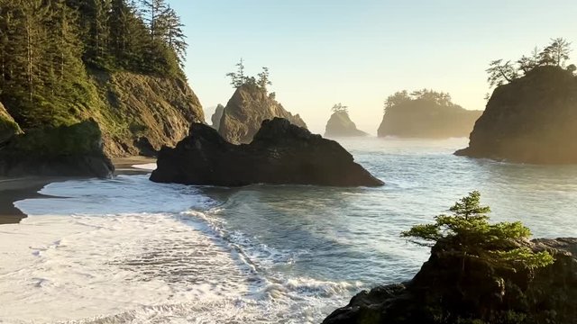 Beautiful beach known as Secret Beach in Oregon with large dramatic rocks with trees on top.