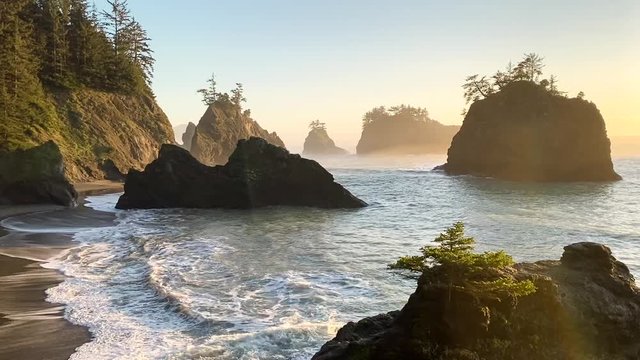Beautiful beach known as Secret Beach in Oregon with large dramatic rocks with trees on top.