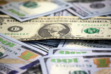 One old dollar bill on background made with one hundred dollar banknotes