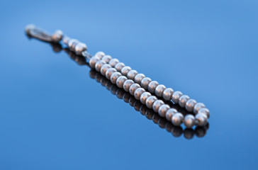 Grey Rosary on blue background
