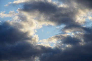 Obraz premium A large dark,black cloud forms in the blue sky. The evening sky before the rain or storm.
