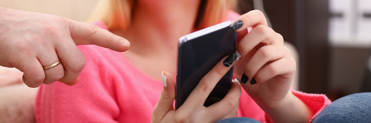 young pretty blond womansit on sofa hold smartphone in hands
