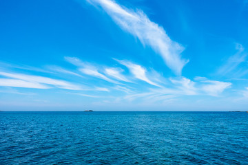 Fototapeta na wymiar 夏の青い海と青い空の間の離れ小島と灯台
