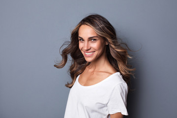 Fototapeta premium Portrait of young beautiful smiling woman wearing white casual T-shirt, looking happily in camera. Wide smile,