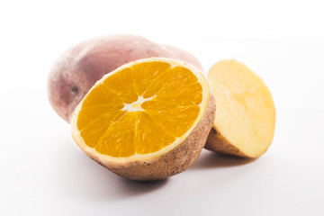 concept of GMO. sliced potatoes with orange inside white background